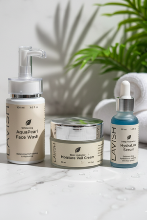 Lavish skincare products including face wash, cream, and serum on a marble surface with a plant in the background.
