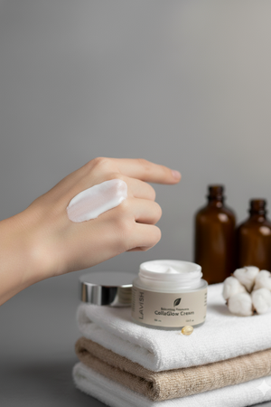 Hand applying cream to a jar with bottles and cotton in the background