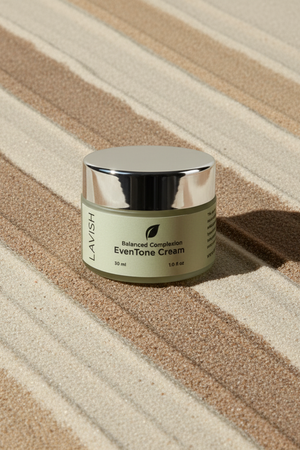 Jar of Lavish Balanced Complexion Even Tone Cream on a striped fabric background