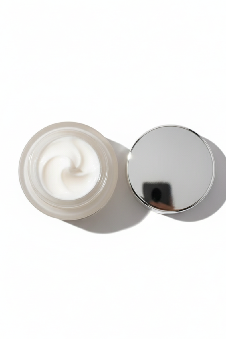 Cream jar with silver lid on a white background